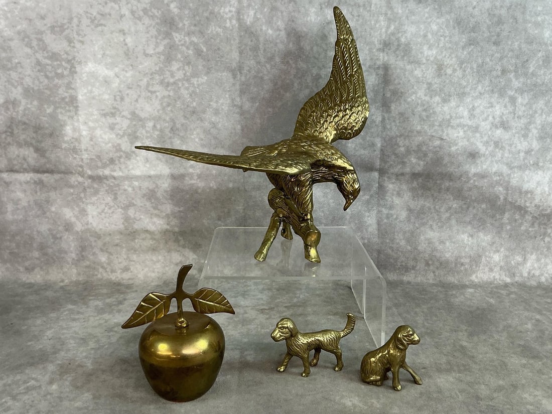Brass Collectibles: Four 1950's brass items, one eagle made in Taiwan, an apple bell made in India, and two dogs made in Taiwan. In good condition. Largest item measures 10 inches long x 6 x 10 inches tall.
