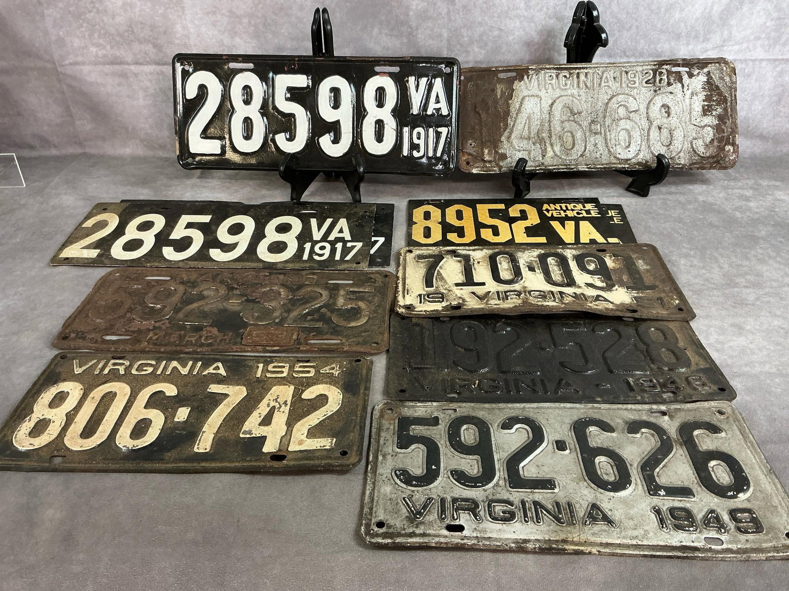 Antique Virginia Plates: Eleven early to mid 1900's license plates. Used plates include (3) 1917, 1928, 1946, 1949' 1951, 1953, 1954, and (2) Antique Vehicle plates. Rust and discoloration present. 1917 plate measures 15