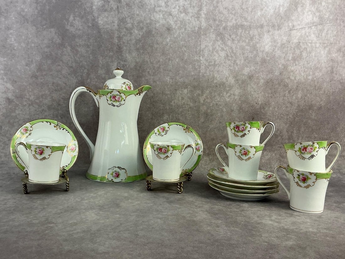 Nippon Chocolate Set: Circa 1910 Nippon hand painted chocolate or tea set featuring roses and gold gilding. Set for six and all in good condition. Pot measures 5.25 inches wide x 9.25 inches tall.
