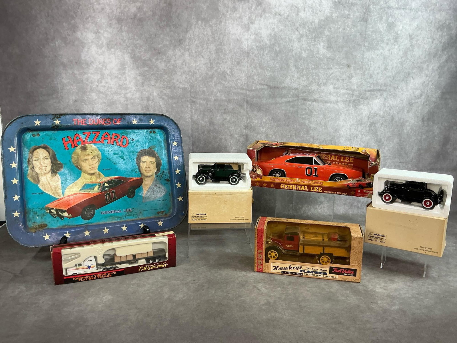 Dukes of Hazzard Collectibles & More: Five Diecast antique model car replicas & TV tray. 1969 General Lee Dodge Charger 1:18 scale. Aluminum Dukes of Hazzard TV tray. 1997 ERTL Kenworth T600B with Flat-bed trailer 1:87 scale. 1931 ERTL Ha