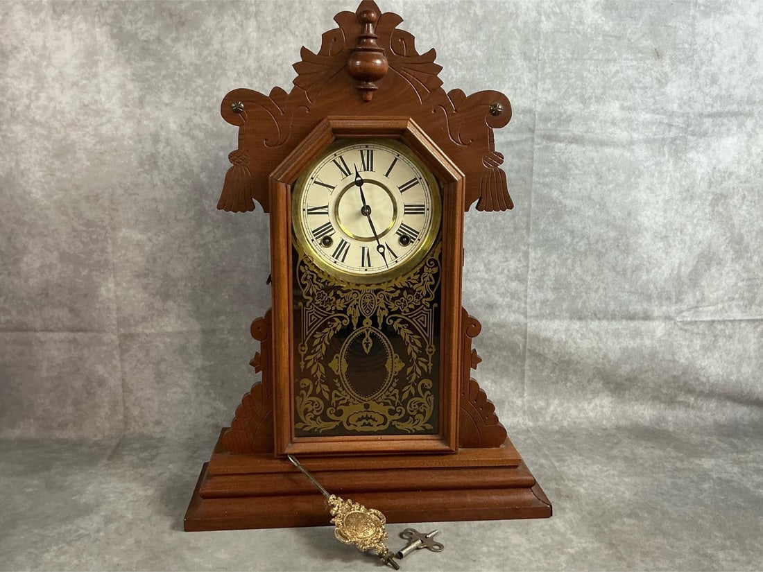 Antique Mantle Clock: Early 1900's parlor mantle clock. "Gingerbread" wooden clock with cast brass pendulum and etched glass door. Untested. Clock measures 14.5 inches wide x 5 x 20 inches tall.