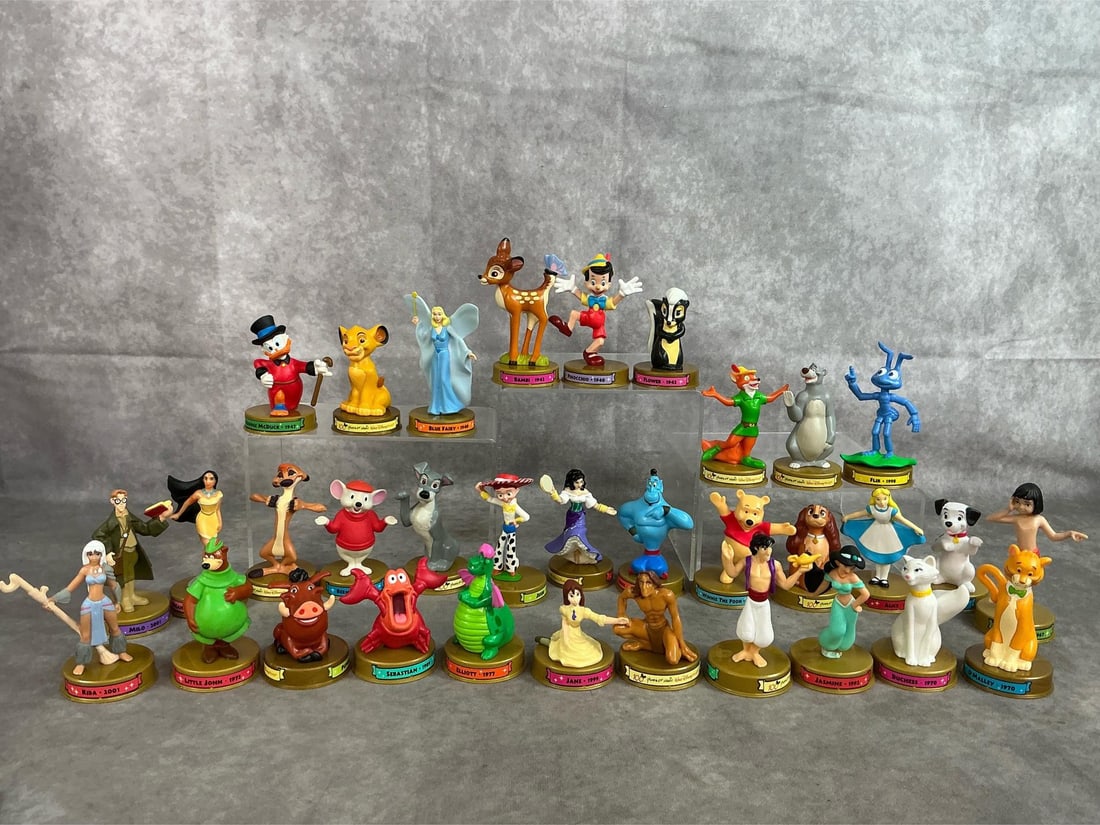 McDonald's Meal Toys: Thirty-three 2002 collectible Happy Meal toys. Disney "100 years of magic" figures. In good condition. Average measures 2 inches in diameter x 3.25 inches tall.