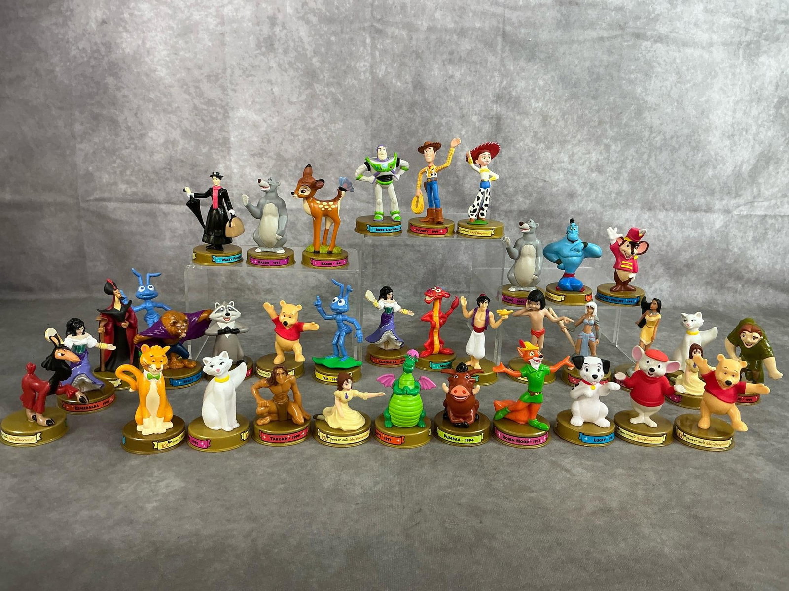 Happy Meal Disney Figures: Thirty-five 2002 "100 Years of Magic" Disney figures. Various collectible characters. In good condition. Average measures 2 inches in diameter x 3.75 inches tall.