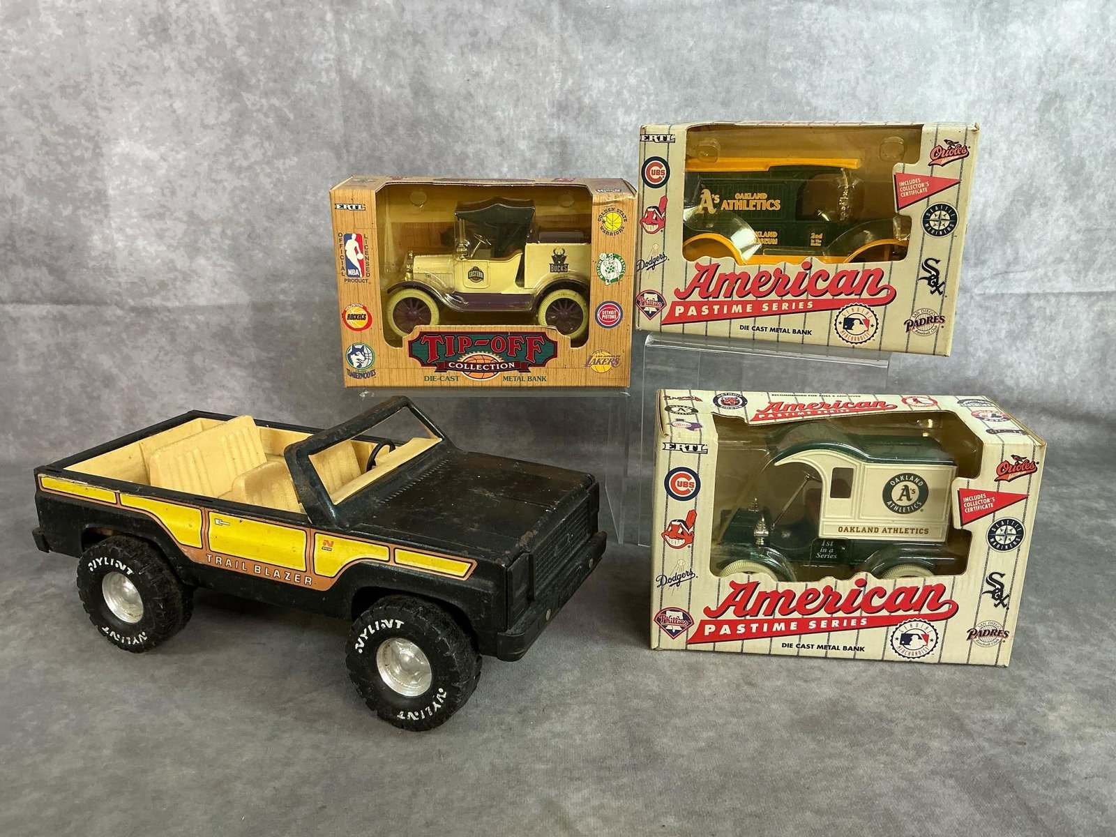 Chevy Blazer & Auto Banks: Four 1970's to 1990's toy blazer and die cast metal bank. Metal Nylint Chevy Trail Blazer 1:14 scale. American pastime series 1920's Oakland Athletics coin banks, and Tip-off metal bank. Rust and
