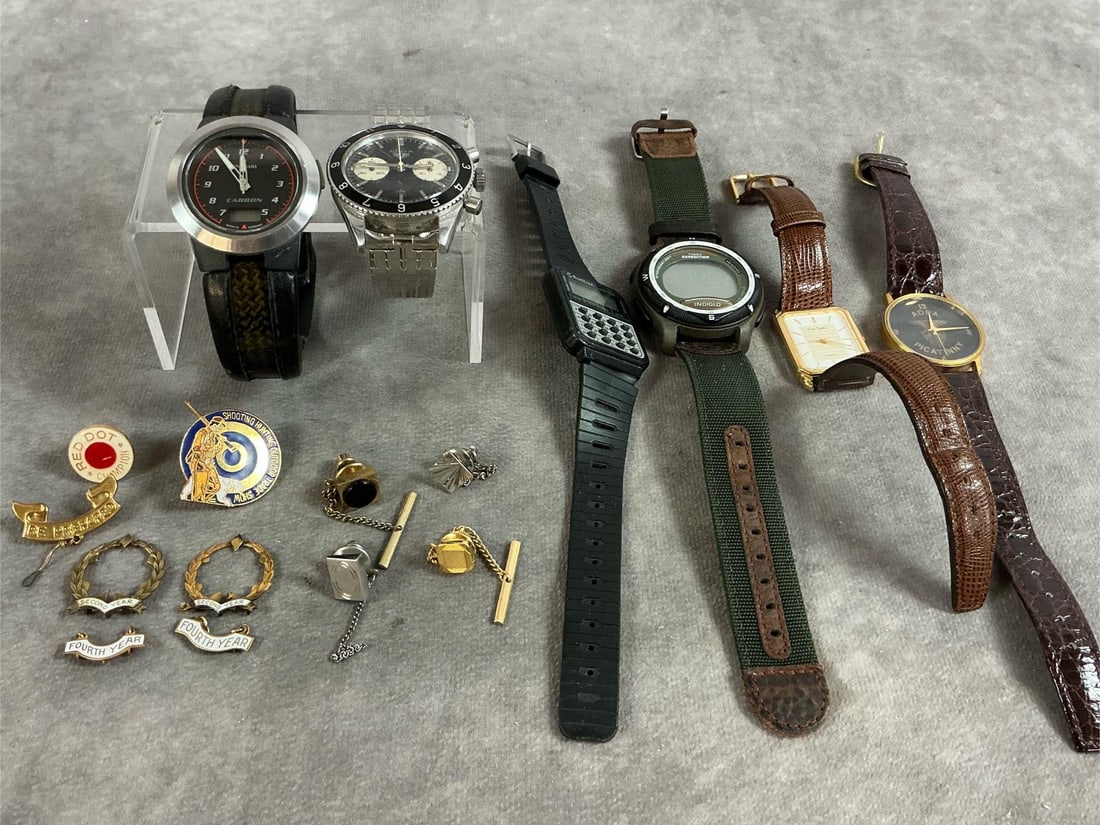 Watches, Tie Tacks & Pins: Seventeen mid to late 1900's watches, tie tacks and commemorative pins. Includes vintage Heuer Autavia "Big Eye" men's watch, Junghans Mega Carbon Watch, Pierre Cardin Quartz watch and more. Includes 