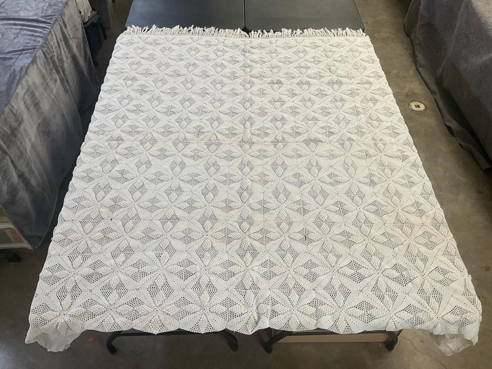 Crochet Coverlet: Vintage handmade white crochet coverlet with fringe along one edge. Good condition other than a few small stains in one spot. Measures 90 inches wide x 69 inches long.