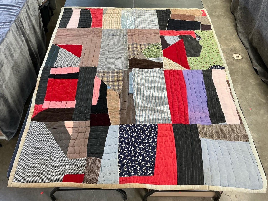 Crazy Quilt: Vintage homemade crazy quilt, machine stitched and hand quilted. Stains on backing and edges. Measures 59 inches wide x 75 inches long.