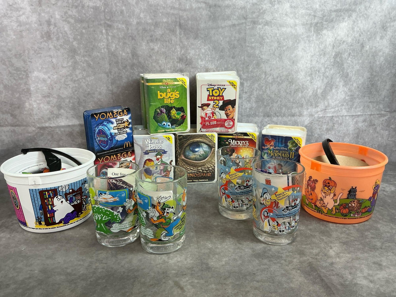 Happy Meal Toys & Glasses: Twenty 2000-2002 McDonald's Happy Meal toys and glasses. Includes twelve Disney video figures in packaging. Four Disney 100 Anniversary glasses, two Halloween Candy Pails, and two Yomega Power Brain