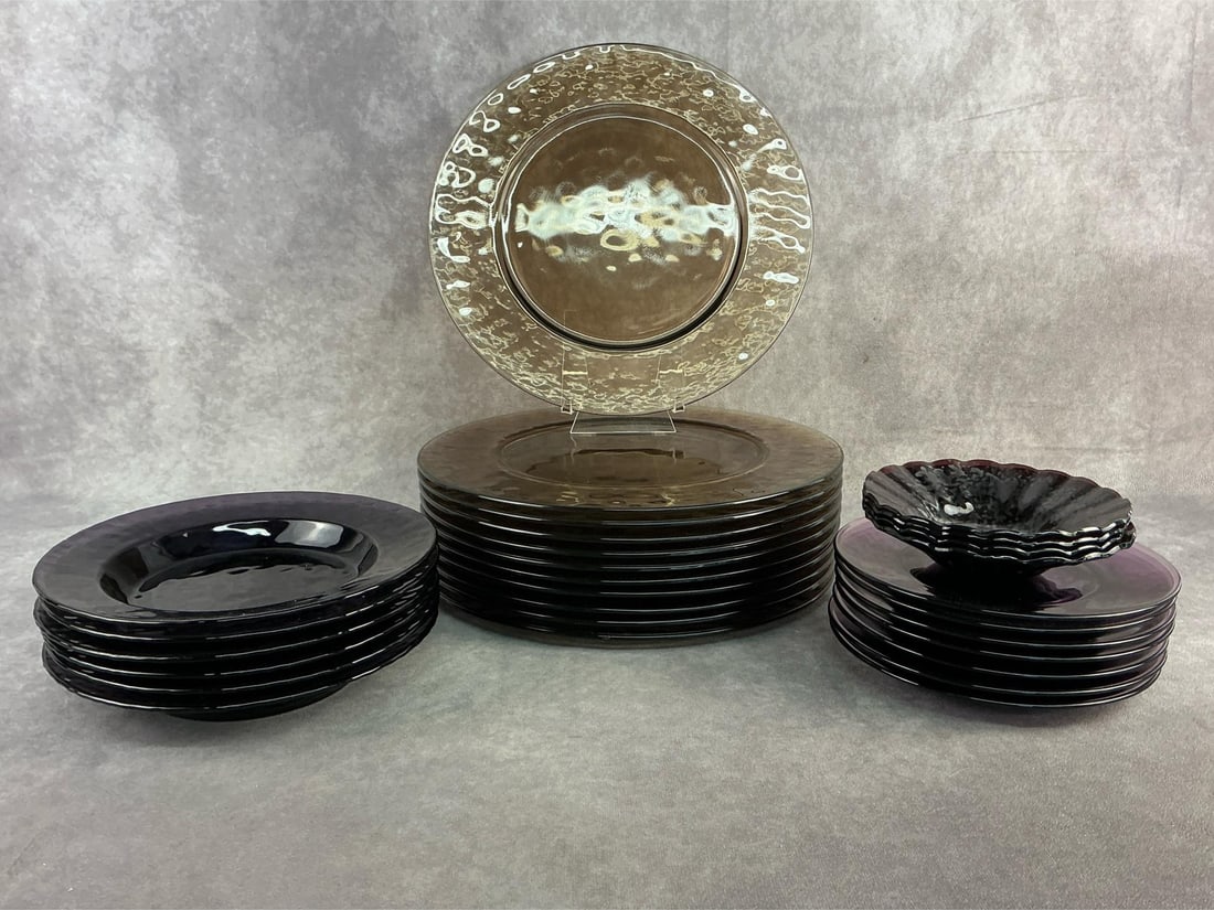 Colored Glassware: Six 1970s Bormioli Rocca Palatine amethyst salad plates, seven amethyst glass plates, four amethyst ruffled bowls, and eleven Smokey hammered glass plates. All in good condition. Largest plates 12 inc