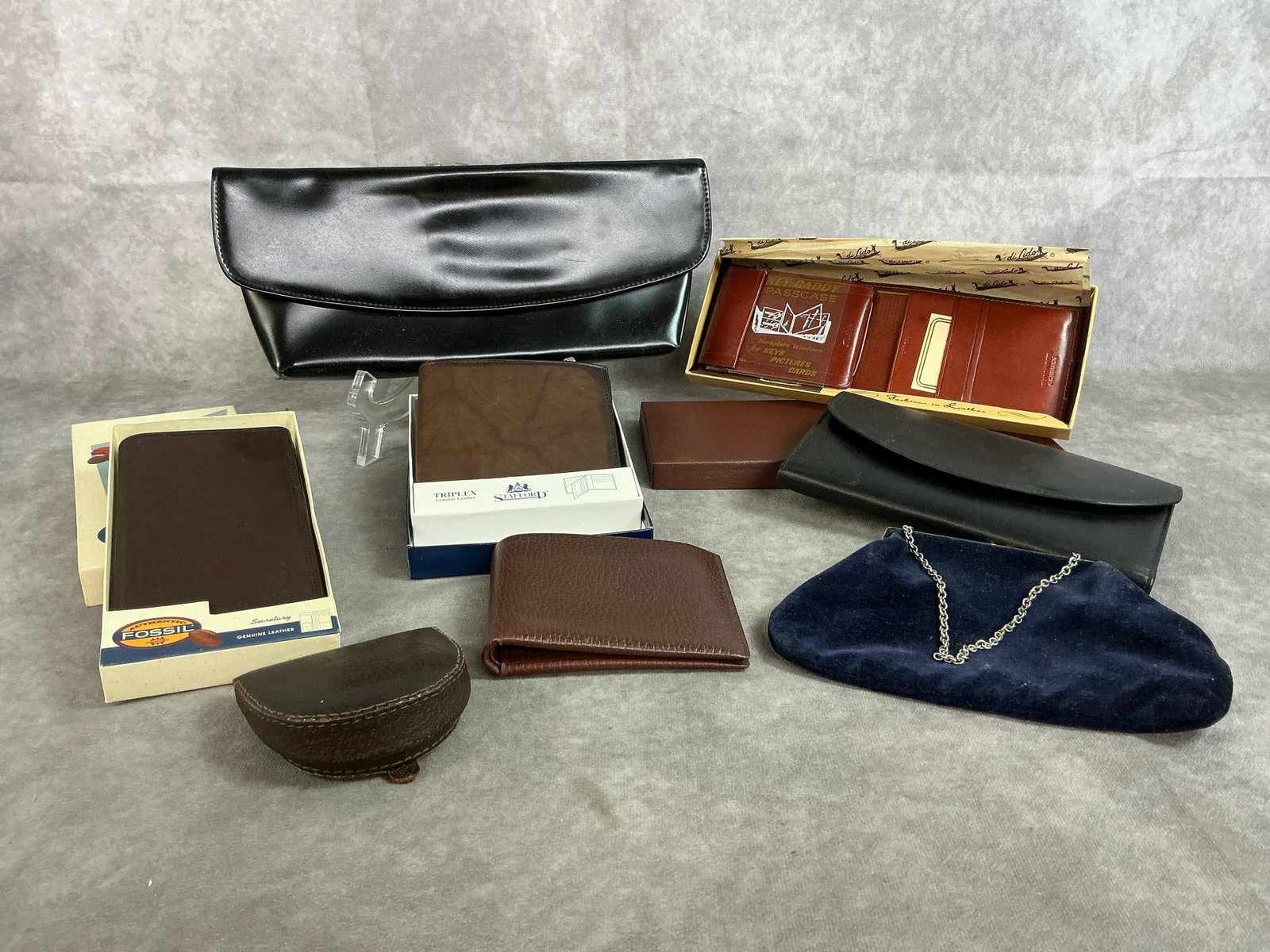 Wallets and Purses: Eight new and slightly used wallets and purses. Five mens wallets and three women's purses. Includes Fossil, Stafford, and di Lido. In good condition. Largest black purse measures 11.5 inches long x 5