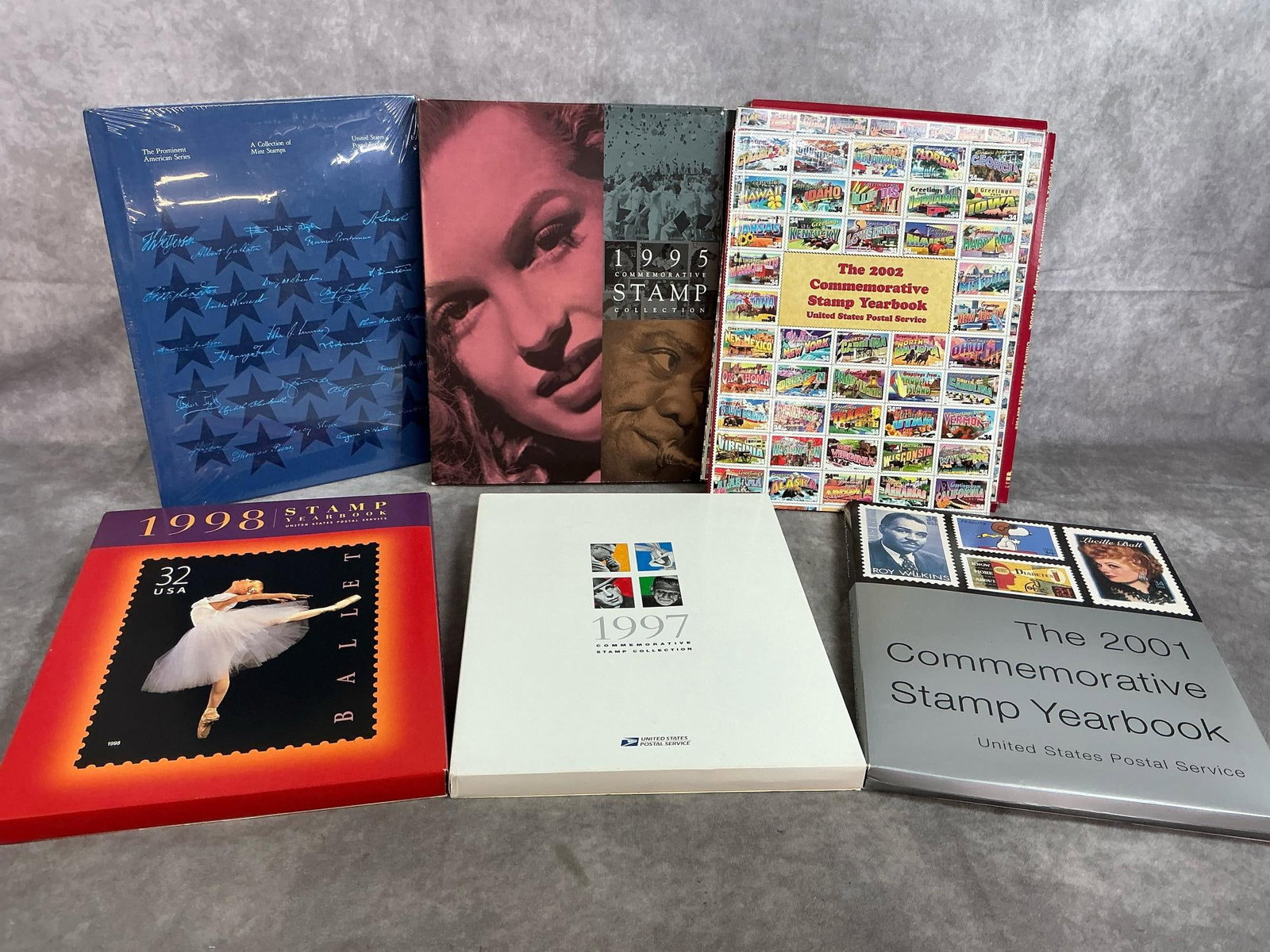 US Postal Stamp Yearbooks: Six commemorative stamp collections yearbooks from 1995-2001. Includes unopened vintage prominent American series mint stamp album. Books are in original outer packaging. In good condition. Each