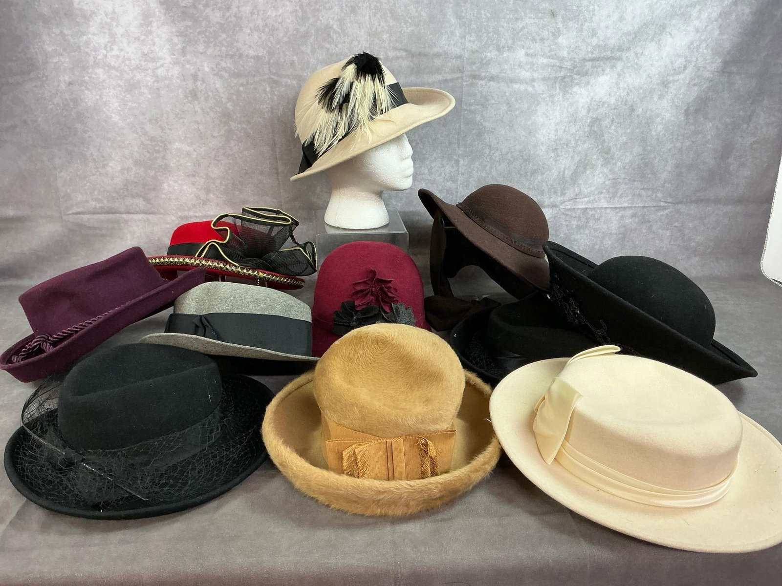 Winter Ladies' Hats: Eleven mid to late 1900's winter hats. Felt and fabric adorned with feathers, ribbons, sequins, and netting. In good condition. Ivory hats measures 13 inches in diameter x 3 inches tall.
