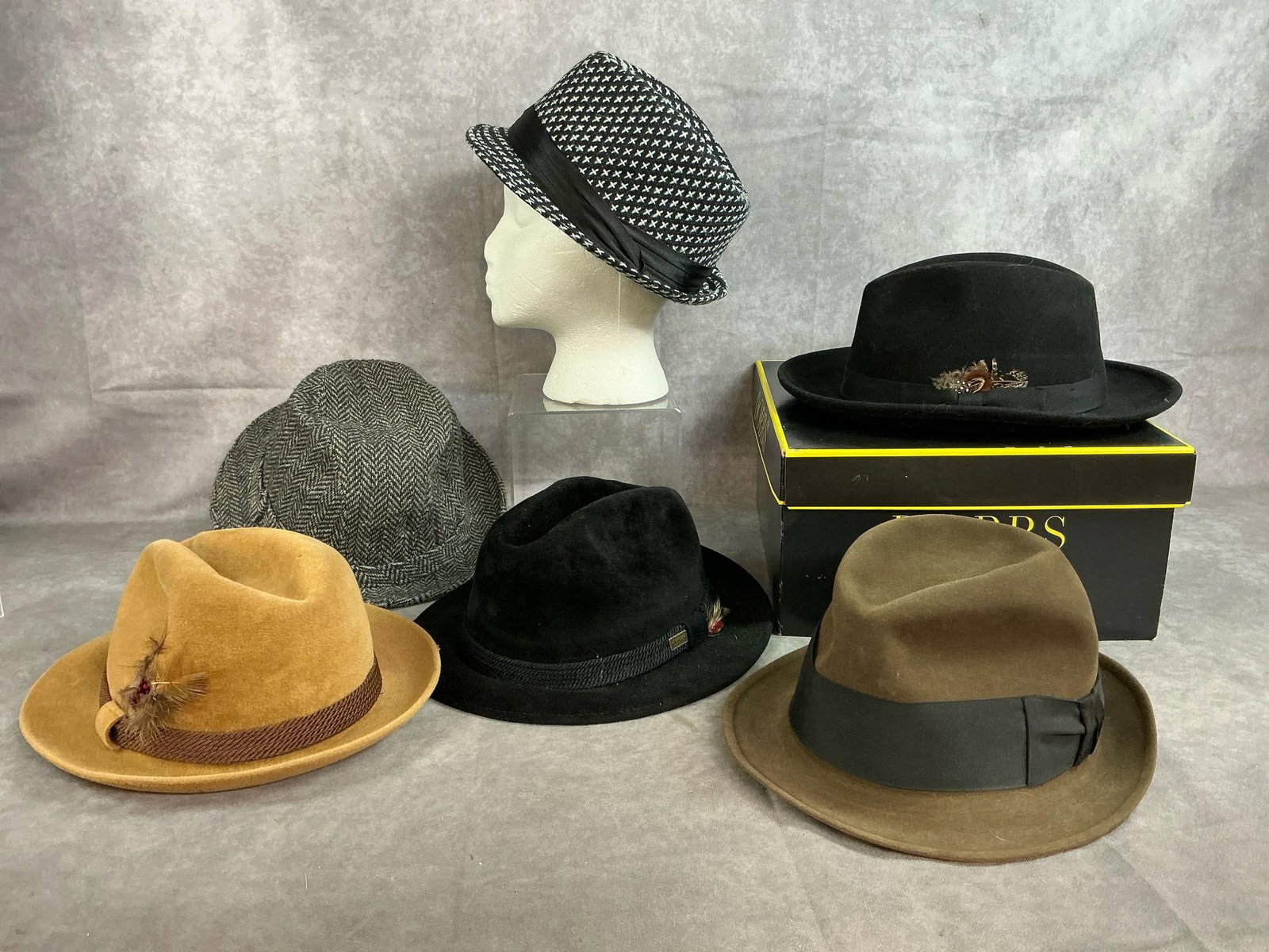 Men's Dress Hats: Six vintage to modern age men's hats. Wool and felt fedoras in tan, brown, black, and patterned style. In good condition. Hat box measures 12 inches wide x 13 x 6.25 inches tall.