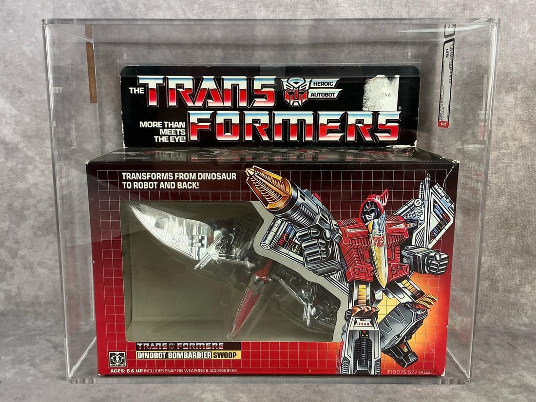 Swoop Transformer 50 VG: 1985 series two Dinobot Bombardier Swoop Transformers made by Hasbro in Japan. AFA graded 50 VG with subgrades: B50 W80 F90. Case measures 10.5 inches wide x 4.25 x 9 inches tall.