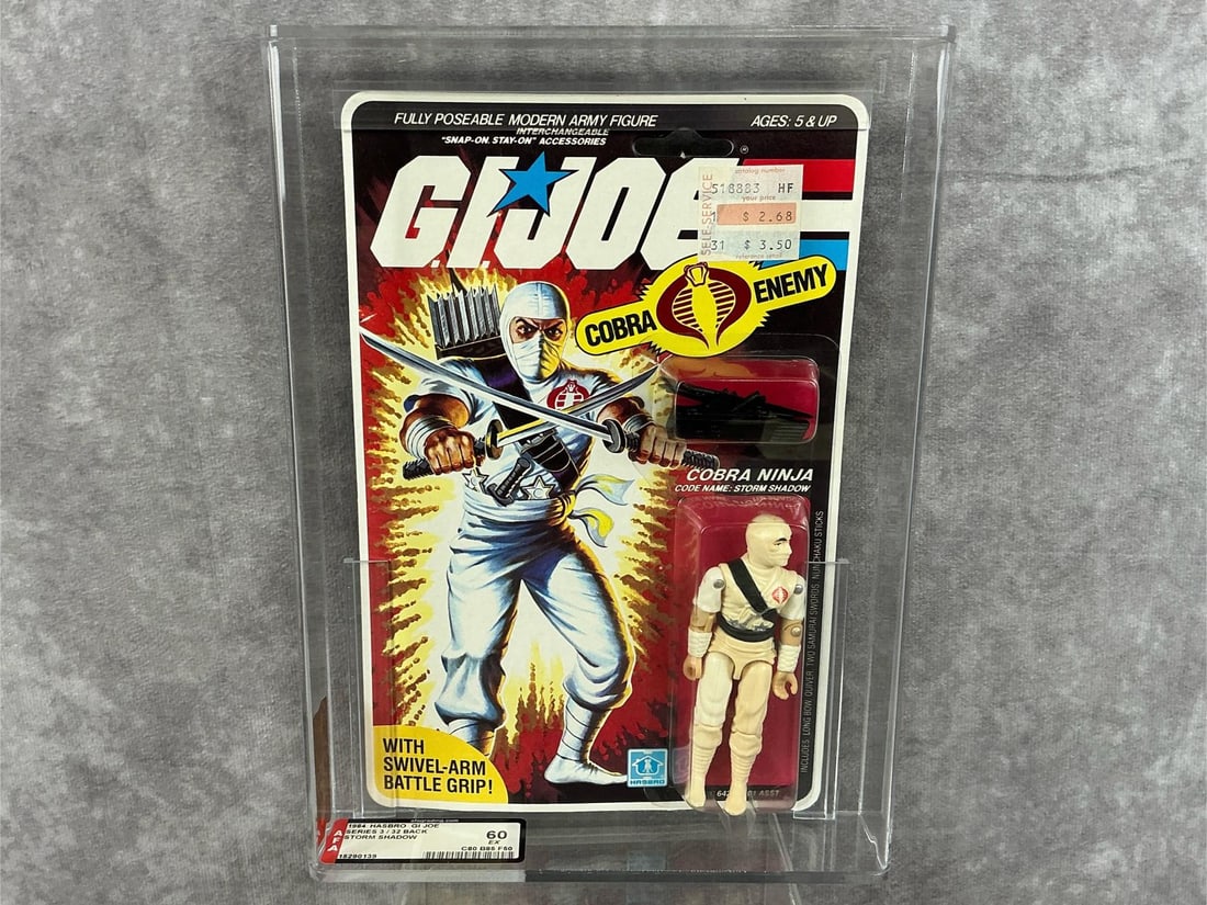 Storm Shadow GI Joe 60 EX: 1984 series three 32 back G.I. Joe Storm Shadow made by Hasbro in Hong Kong. AFA graded 60 EX with subgrades: C80 B85 F50. Case measures 7.25 inches wide x 1.5 x 9.75 inches tall.