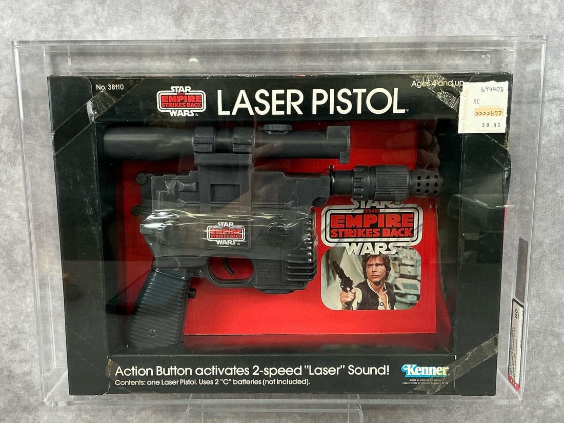 Laser Pistol ESB 80 NM: 1980 Han Solo on background variation Laser Pistol, made by Kenner in Macao. AFA graded 80 NM. Case measures 13.5 inches wide x 2.5 x 9.75 inches tall.