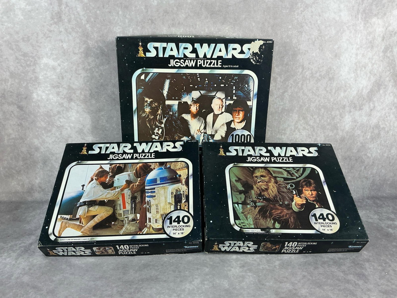 Star Wars Puzzles: Three 1977 Star Wars jigsaw puzzles, two 140 piece puzzles and one 1000 piece. Well taken care of, but pieces are not verified. Wear to boxes. Largest measures 12.25 inches wide x 2.25 x 10 inches