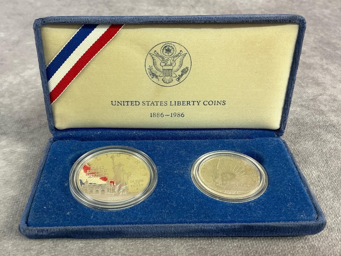 Liberty Two Coin Proof Set: 1986 Statute of Liberty two coin proof set containing a commemorative silver dollar featuring Ellis Island. Both in good condition with silver dollar containing 90 percent silver. Total weight 1.11 oz