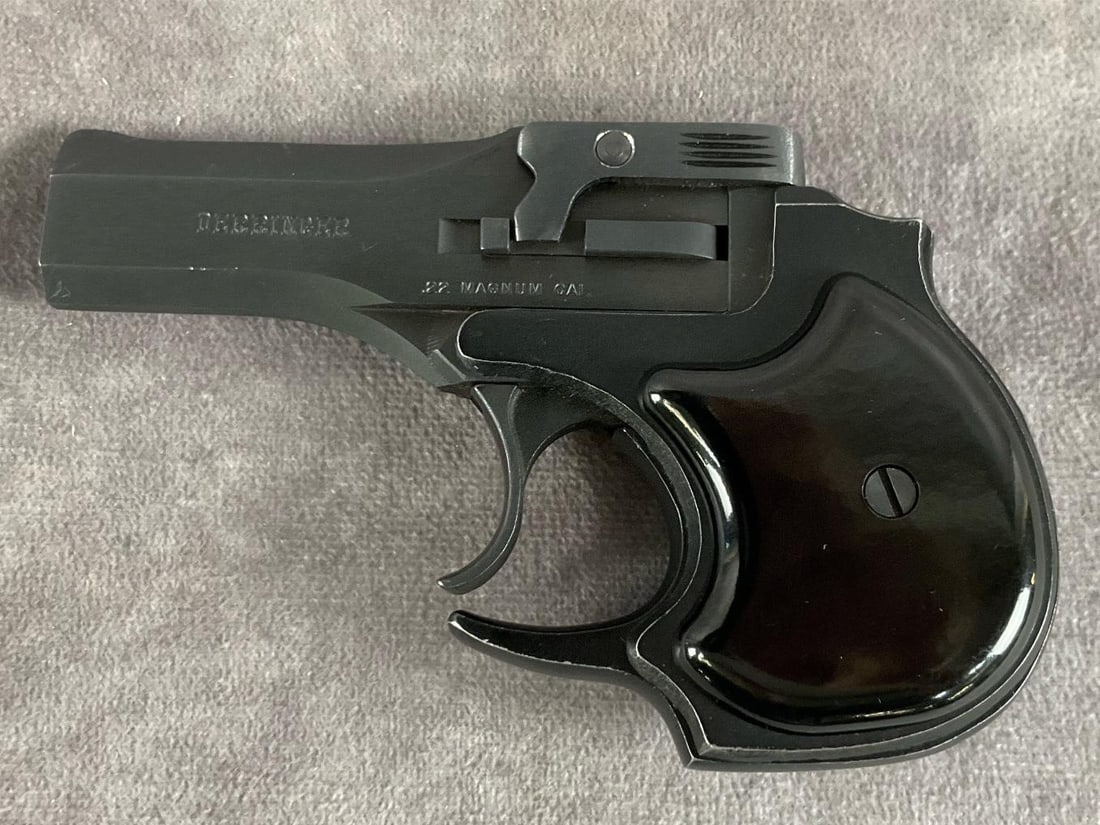 High Standard 22 Magnum Derringer: Serial # D46300 .22 Magnum double-barrel Derringer by High Standard in black finish with zippered leather pouch. Good condition with minor edge wear and handling marks. Barrel length 3 1/2 inches,