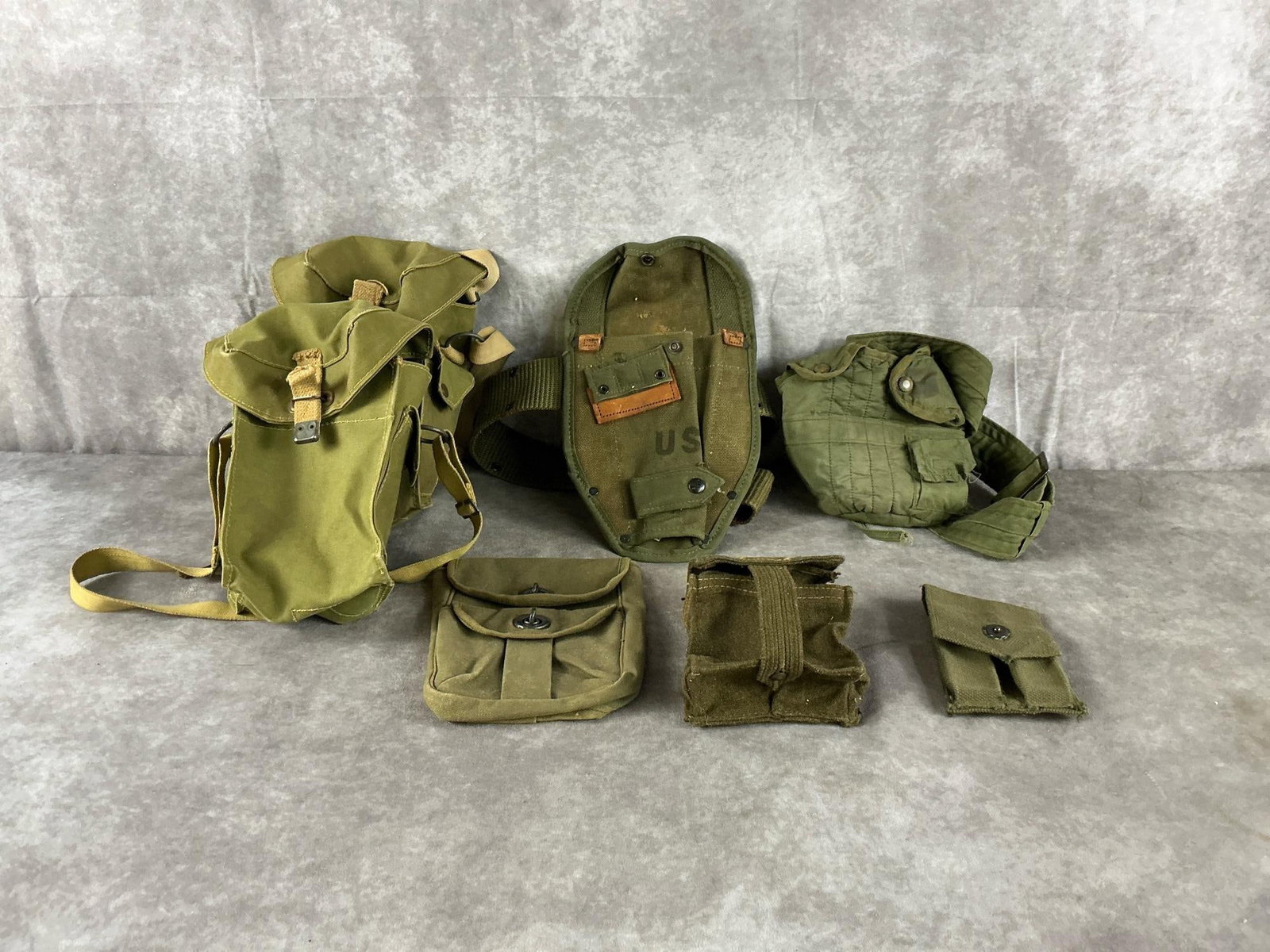 US Military Canvas Field Gear: Vintage canvas field gear assortment by US Military in olive drab. In fair condition. Largest bag measures 7 inches long X 5 inches deep X 9 inches high.