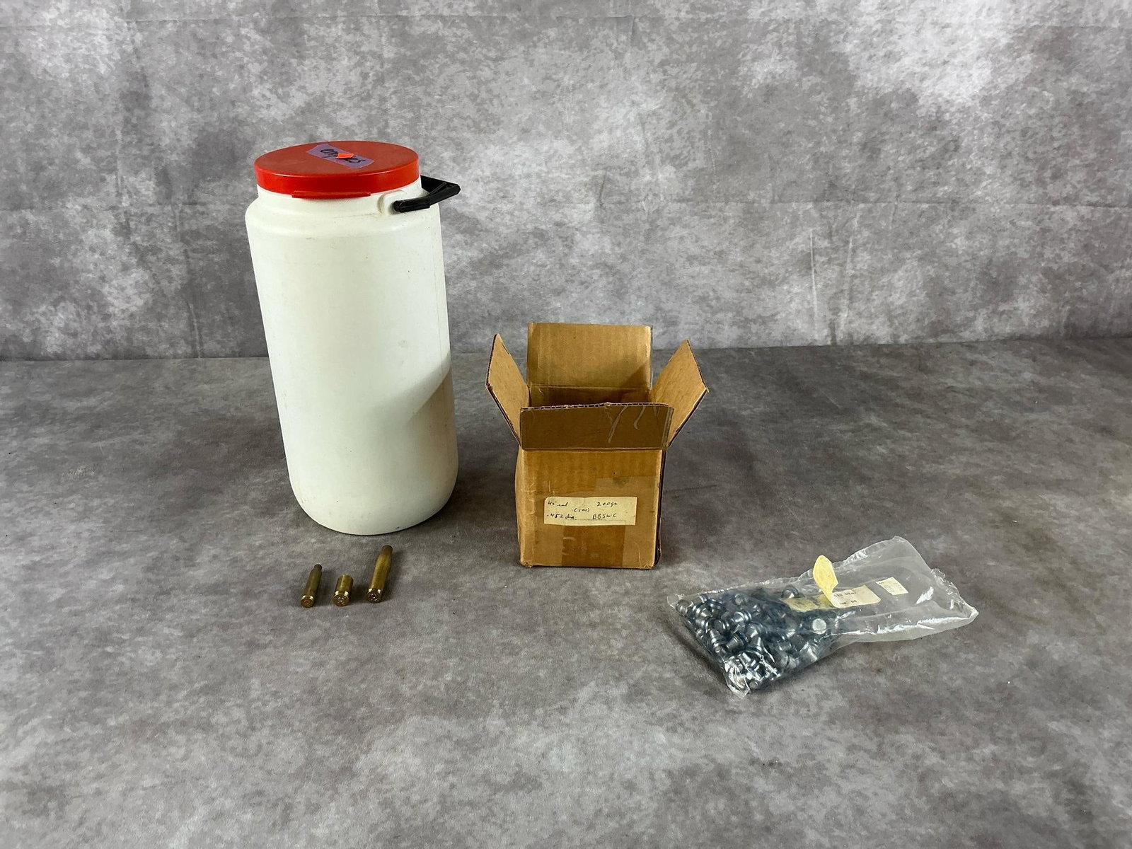 W-W & R-P Reloading Components: Estimated 75 ea .45 caliber 155gr and 200gr lead reloading projectiles, conical milling teeth, and 30-06 SPRG, 45 Auto and 6mm spent brass casings by W-W and R-P. In fair condition. Jar measures 12