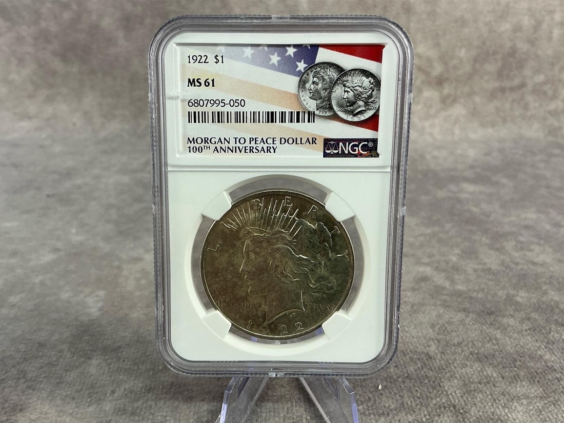 Peace Dollar: 1922 US Peace Silver Dollar, MS 61, graded by NGC. Certification number 6807995-050. Measures 2.25 inches wide x 3.25 inches tall.