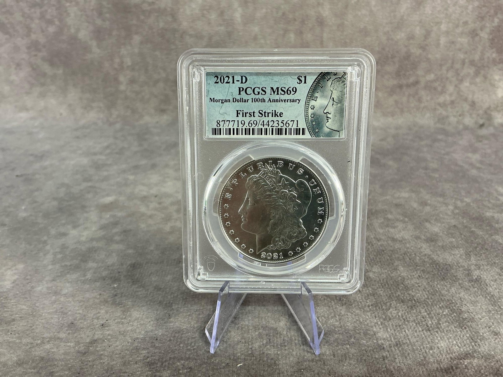 Morgan Dollar: 2021D Morgan Silver Dollar, MS 69, graded by PCGS. First Strike, Certification number 877719.69/44235671. Measures 2.25 inches wide x 3.25 inches tall.