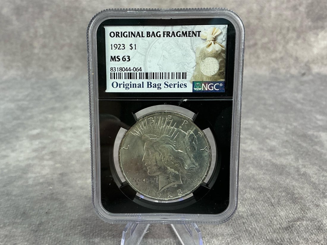 Peace Dollar: 1923 US Peace Silver Dollar, MS 63, graded by NGC. Certification number 8318044-076. Measures 2.25 inches wide x 3.25 inches tall.