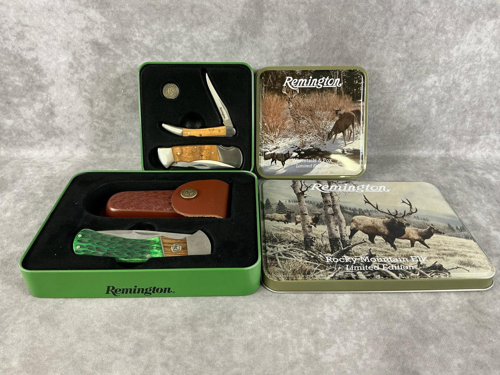 Remington Knives: Two modern gift sets made by Remington in their original tins. One Whitetails & Fox and one Rocky Mountain Elk with leather sheath. Both in good condition. Largest tin measures 7 inches wide x 1.25 x