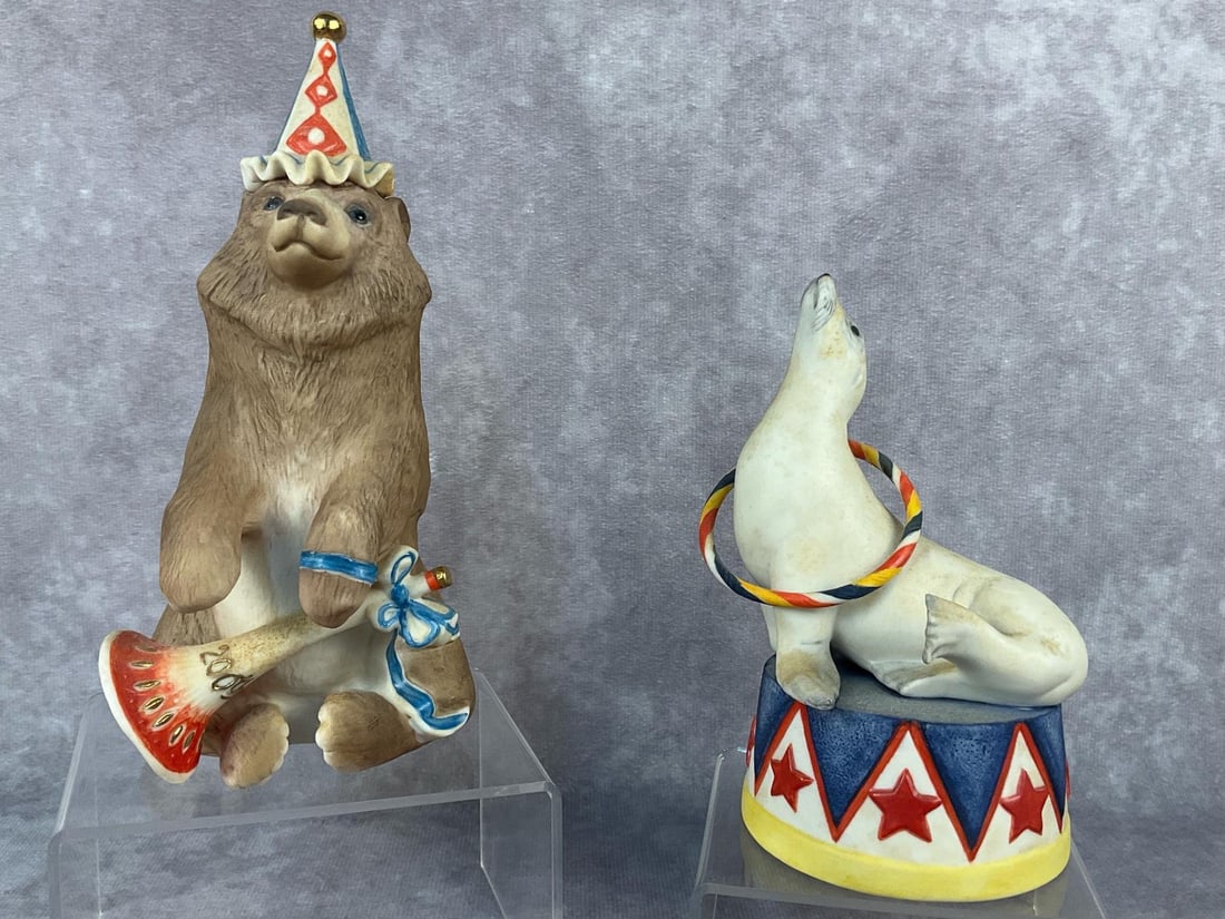 Bear & Seal Circus Collectibles: Two vintage Cybis porcelain figurines. Includes "Sebastian the Circus Sea" dated 1976 and "Barnaby the Circus Bear" dated 1975. Both signed and in good condition. Barnaby measures 3.25 inches long x