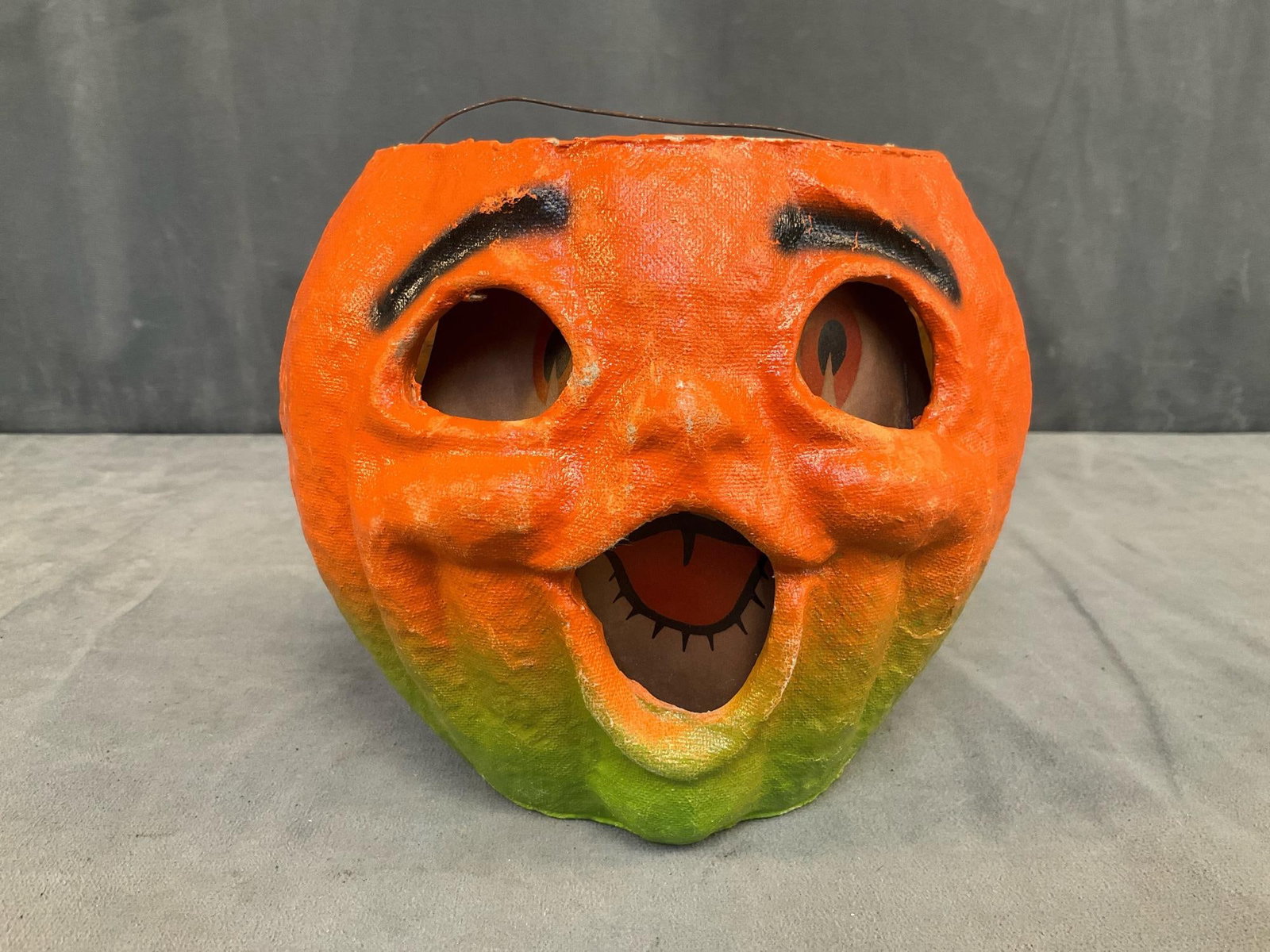 Jack-o'-Lantern Pail: 1940's-1950's molded pulp paper mache "Choir Boy " Jack-o'-Lantern candy pail with paper face insert and wire bail handle. Missing light bulb, battery holder and green cardboard top operating