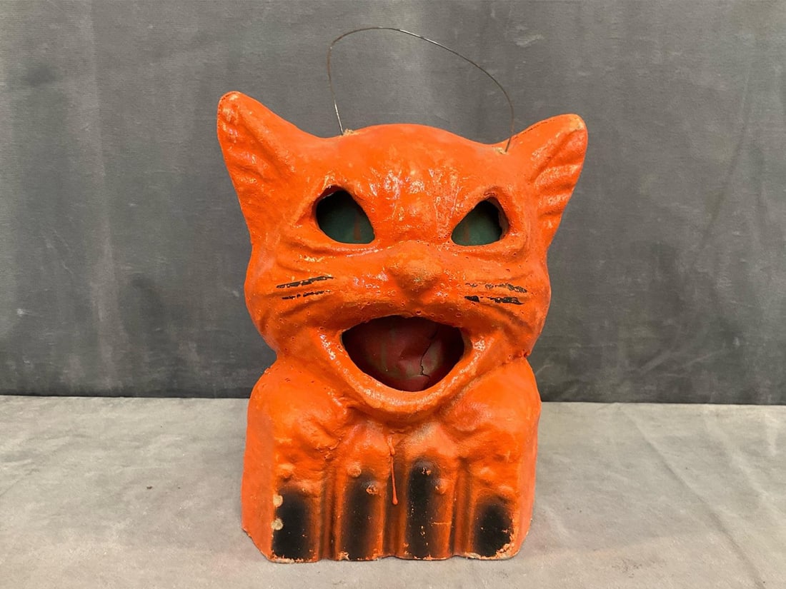 Jack-o'-Lantern Pail: 1930's - 1940's molded pulp paper-mache cat head on fence Jack -o' Lantern candy pail with paper face insert and wire bail handle. Minor wear on ears, insert tear in mouth and small candle charred