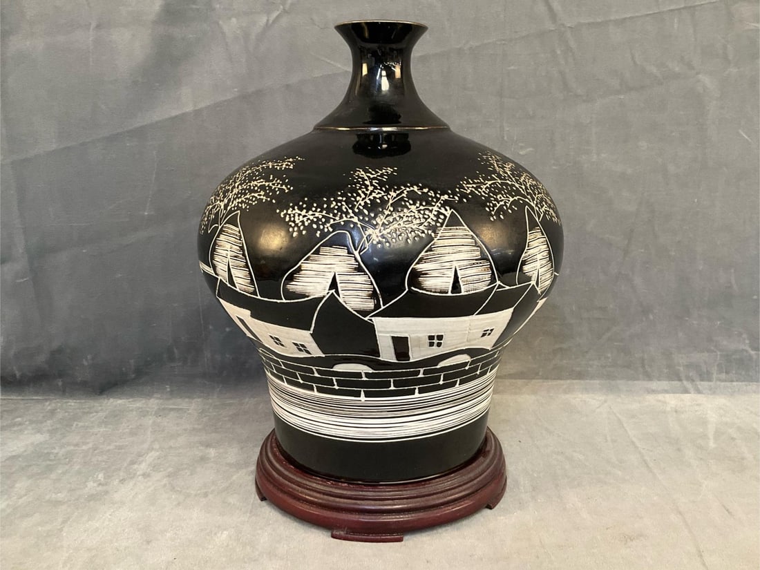 Asian Vase: Late 20th century contemporary Asian pottery vase on wooden stand with sgraffitto decoration on black and white glaze. Illegible signature incised on bottom. Good condition. Measures approximately 9