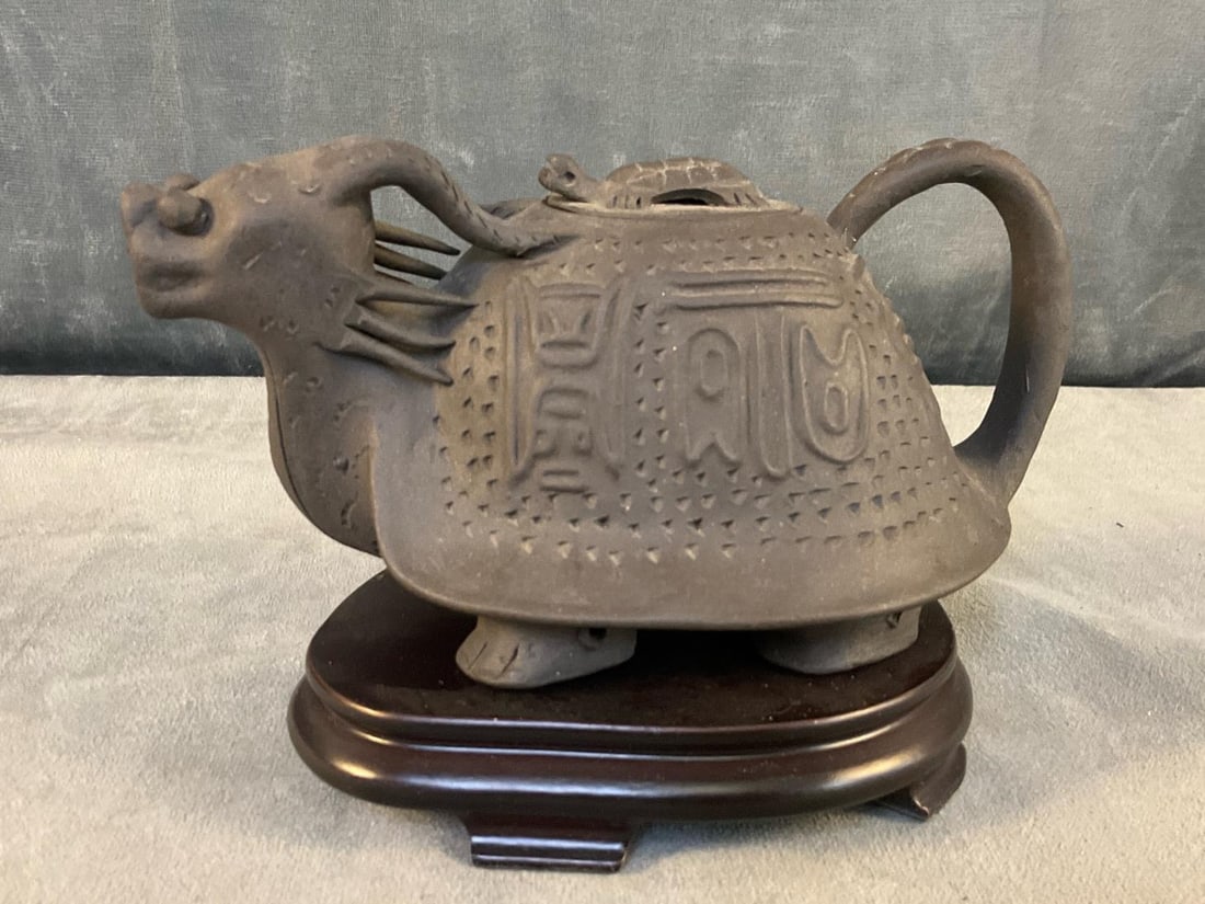 Chinese Teapot: Modern Chinese archaic-style unglazed Yixing dragon-turtle teapot on wooden stand with illegible signature seal under lid and teapot. Good condition. Measures approximately 6 inches wide x 3.75 x