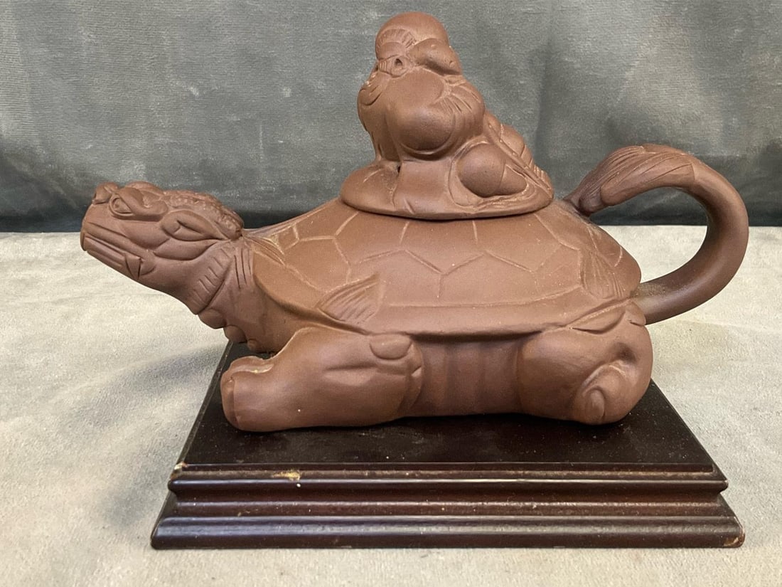 Chinese Teapot: Modern Chinese archaic-style unglazed Yixing dragon-turtle teapot on wooden stand with illegible signature seal under lid and teapot. Good condition. Measures approximately 7.75 inches wide x 4 x 4