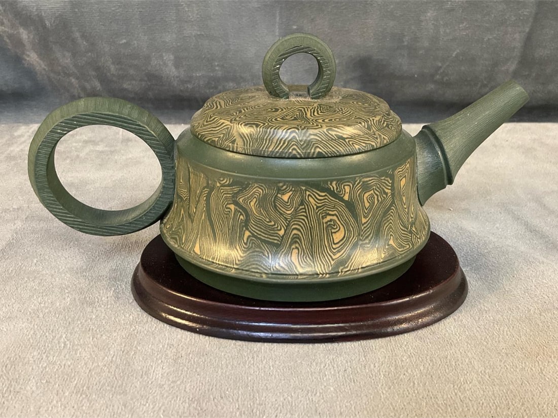 Chinese Teapot: Modern Chinese marbled Yixing Zisha unglazed green clay teapot on wooden stand with illegible signature seal under lid and teapot. Good condition. Measures approximately 7 inches wide x 3.75 x 3