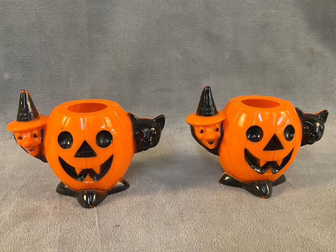 Jack-o'-Lanterns: Two 1950's Rosbro plastic candy container Jack-o'-Lanterns with attached witches and black cats. Good condition. Measures approximately 4 inches wide x 2 x 3 inches tall.