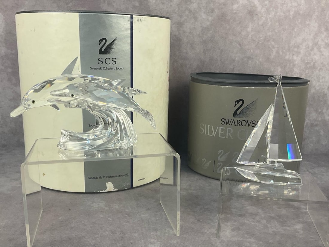 Swarovski Figurines: Two 1990-1994 Swarovski Crystal collectible figurines. Annual edition "Lead Me" - the Dolphins and " When we were Young" - the Sailing Boat. Both are still in original box and in good condition.