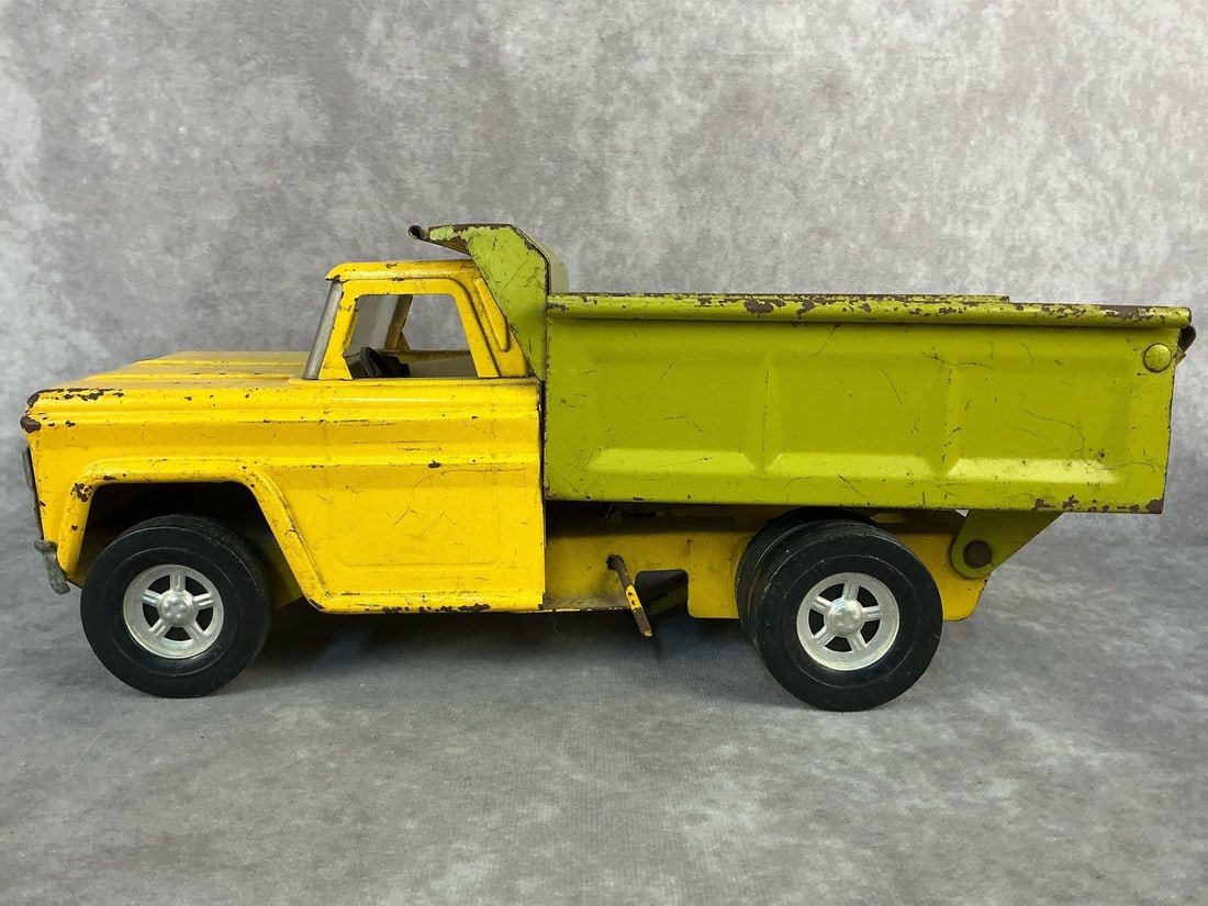 Strucro Dump Truck: 1960's Structo pressed steel toy dump truck. Normal wear and rust from age and there is a crack in the windshield. Otherwise good condition. Measurements are 13.5 inches long x 5.5 x 5.75 inches tall.