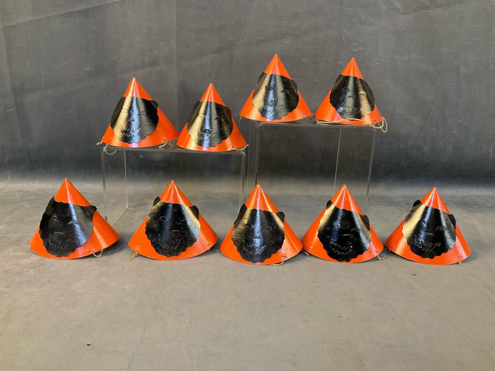 Halloween Hats: Nine 1950's-1960's children's black and orange Halloween party hats with die cut cat faces and string neck straps. Several cat faces with minor white discoloration, otherwise good condition. Measures