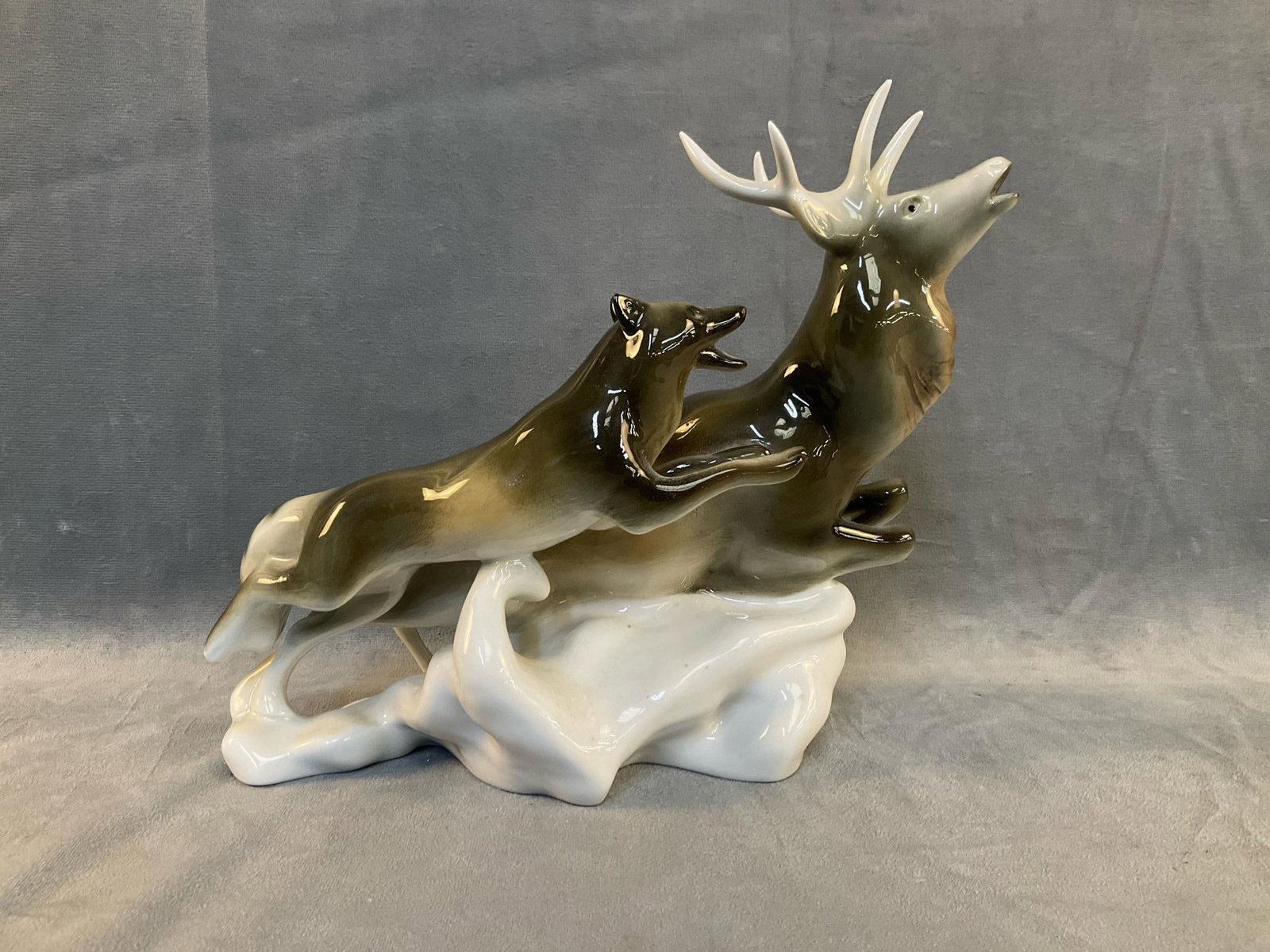 Czech Porcelain: Post 1993 Royal Dux Bohemia porcelain figure of a stag and wolf. Stamped on bottom. Good condition. Measures approximately 10 inches wide x 4.5 x 8.25 inches tall.