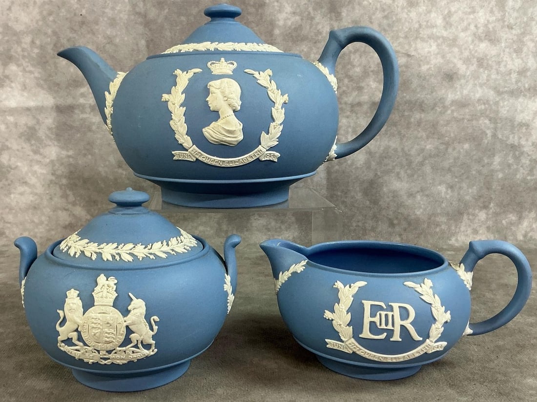 Coronation Wedgewood Tea Set: 1953 teapot, sugar bowl, and creamer. Wedgewood pale blue Jasper set featuring coronation of Queen Elizabeth II of England. In good condition. Teapot measures 9 inches wide x 5 inches tall.