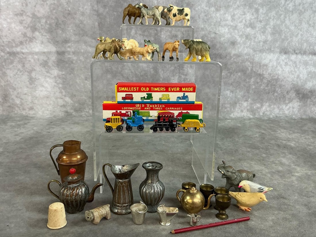 Collection of Miniatures: Thirty-six mid to late 1900's miniatures. Includes twelve carved bone animals from Japan, miniature metal "Old Timers" cars and train cars, variety of metal pitchers, pots, and buckets, and more. Slig