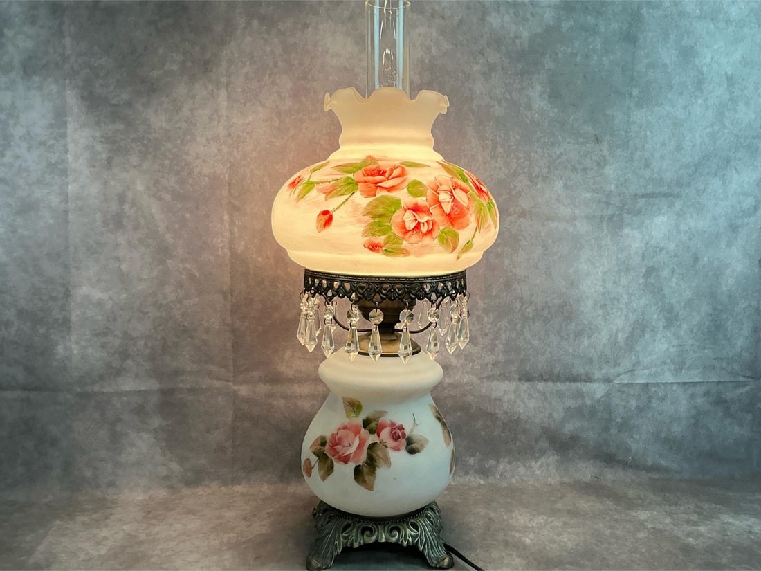 Adelaide Parlor Lamp: Late 1900's hurricane table lamp. "Touch of Class" Adelaide Victorian electric lamp with pink roses on milk glass on metal base. In good condition. Measures 9 inches wide at top shade x 24 inches
