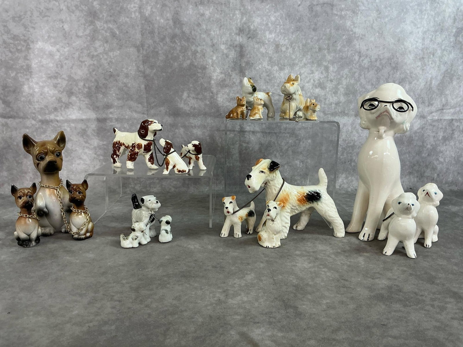Dog Families: Seven mid 1900's dog with pups family sets. Includes poodles, terriers, and chihuahuas. Two sets have broken chains. Some slight color loss, otherwise in good condition. Poodle measures 3 inches wide