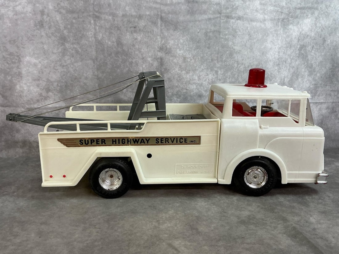 Toy Highway Tow Truck: 1960's Marx "Big Bruiser" Super Highway Service truck. Hard plastic with battery operated winch and boom. Untested. Boom is broken at truck bed. Measures 22 inches long x 8 x 9 inches tall.