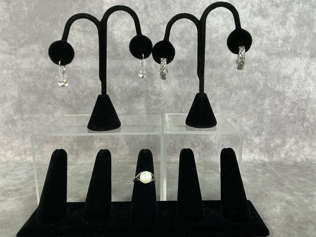 Sterling Silver Jewelry: Three Sterling Silver jewelry pieces. Included are a pair of Rhodium Plated over sterling silver Luce 8.34 CTW earrings, a pair of Rhodium over sterling silver Byzantine hoop earrings and a Grande