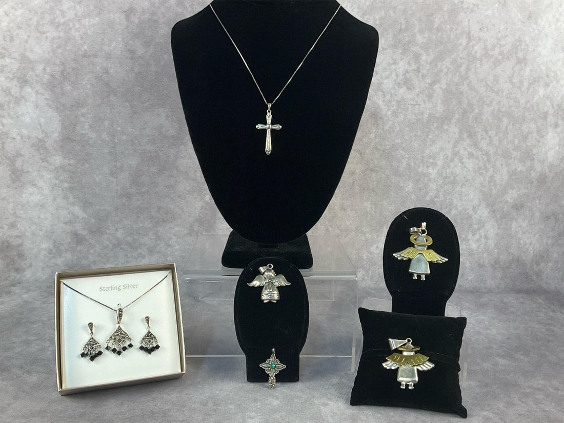 Sterling Silver Angel Pendants & More: Seven sterling silver jewelry pieces. Lot includes a chain with a cross pendant, three angel pendants, a cross pendant with malachite center stone and a marcasite necklace and earrings set. All in