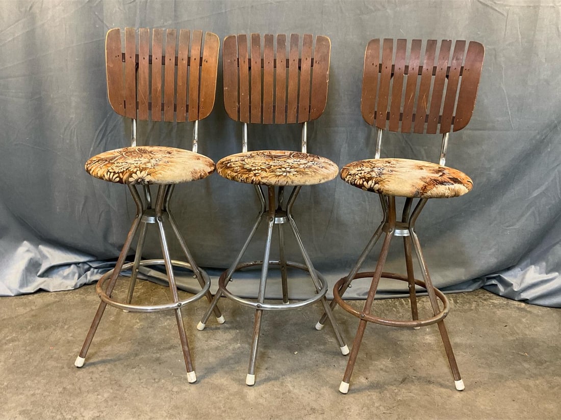 Barstools: Three 1960's chrome barstool chairs with upholstered seats and wooden slat backs. Surface rust and scratches. Measures 13.5 inches wide x 19 x 38.5 inches tall.