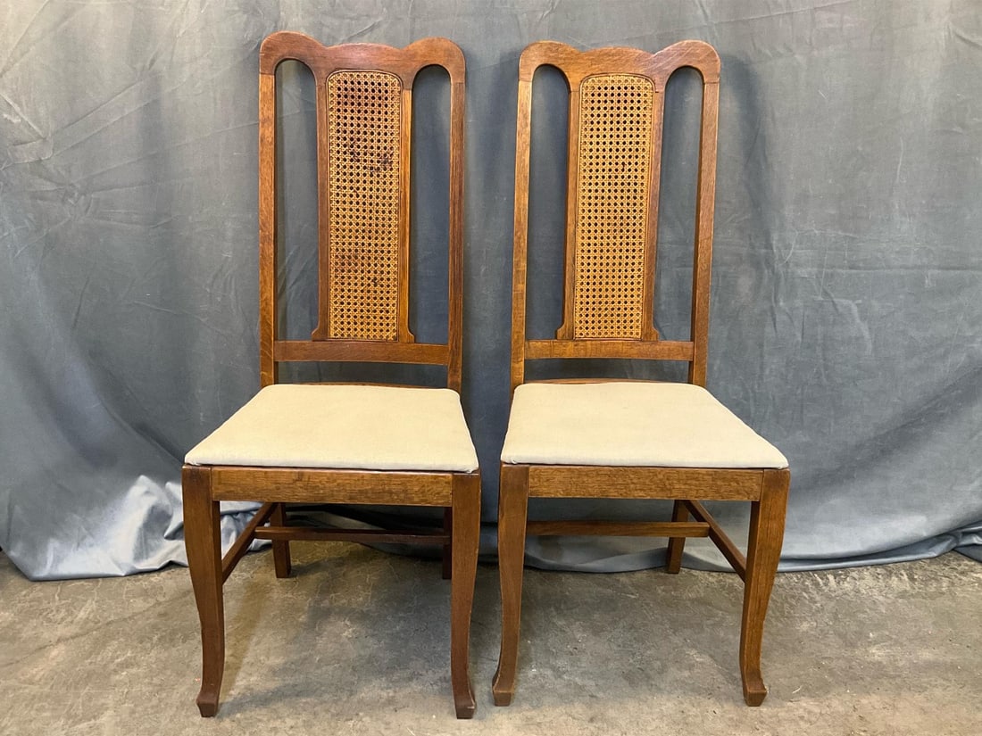 Side chairs: Two mid-20th century oak side chairs with upholstered seat and cane back splats. One chair with loose joints and small spot on seat, otherwise good condition. Measures 18 inches wide x 17 x 43 inches